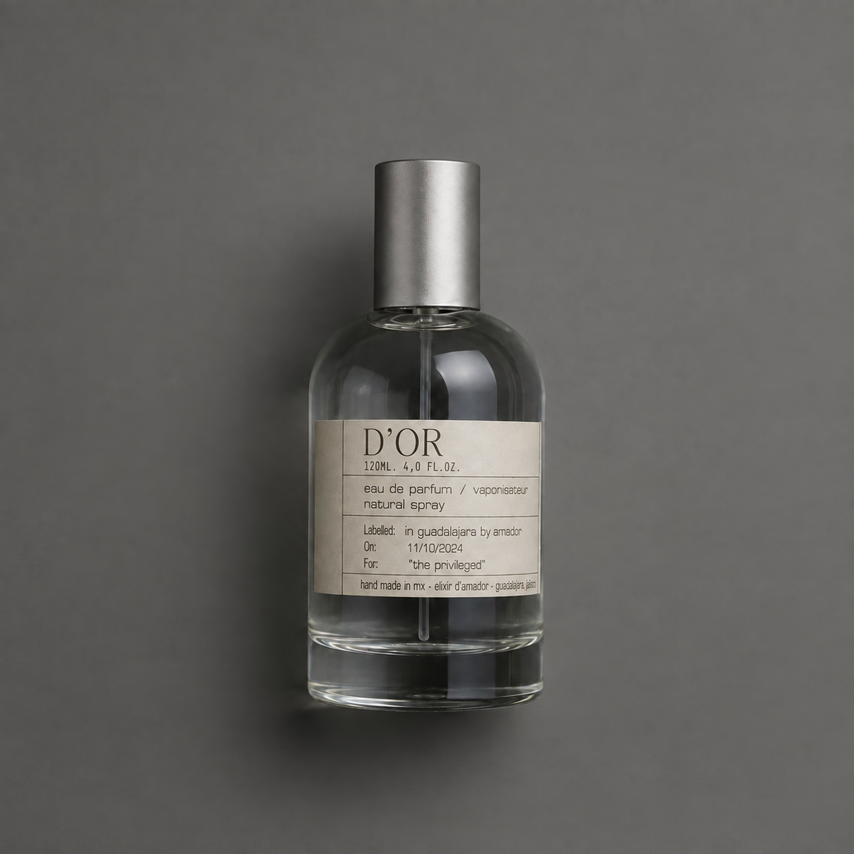 D’Or de Elixir Amador: frasco cilíndrico de 120 ml sobre fondo gris.