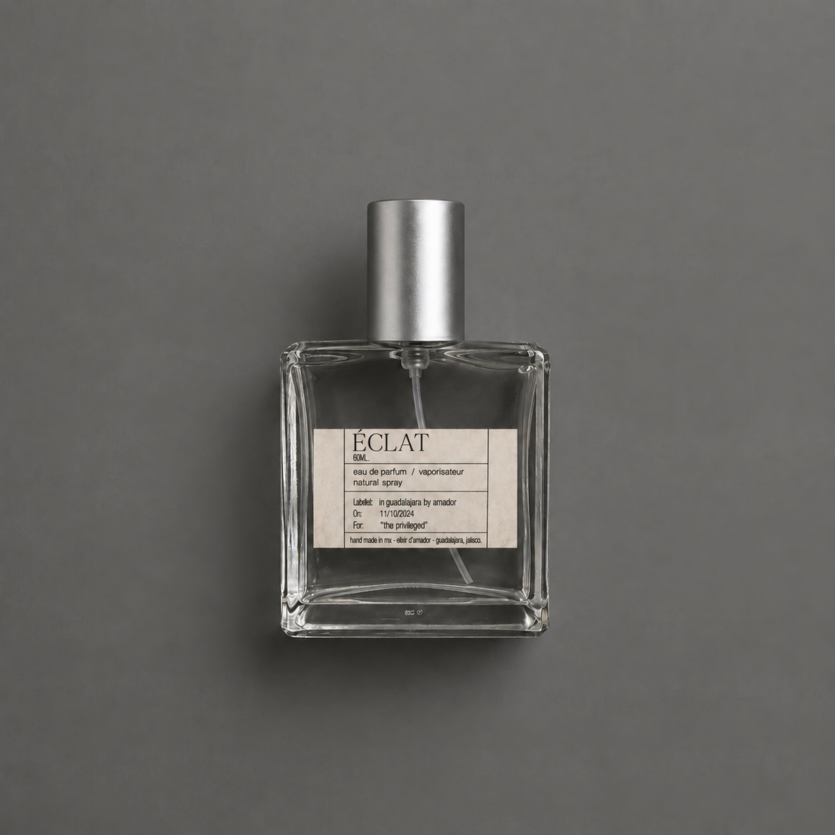Éclat de Elixir Amador: frasco cuadrado de 60 ml sobre fondo gris.
