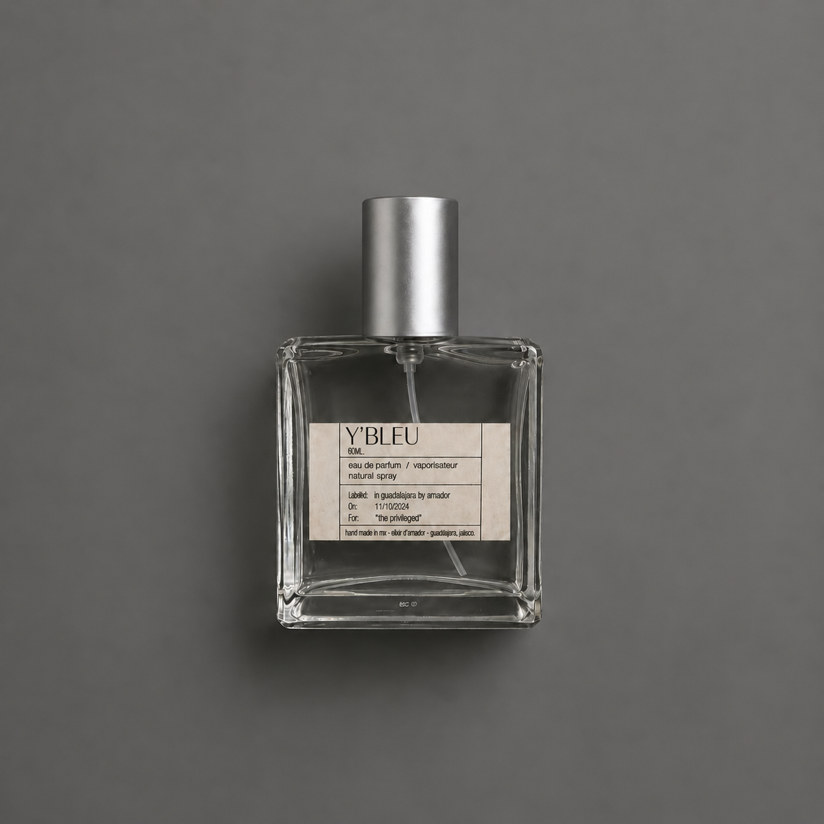 Y’ Bleu de Elixir Amador: frasco cuadrado de 60 ml sobre fondo gris.